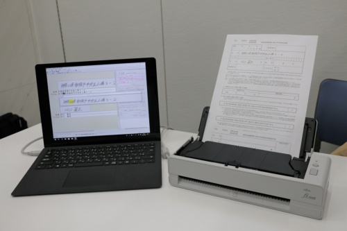 「AI日本語手書きOCRオプション」の利用シーンの例。紙文書をスキャナーにかけると、オプションソフトなどを搭載したノートパソコンで手書き文字を読み取れる